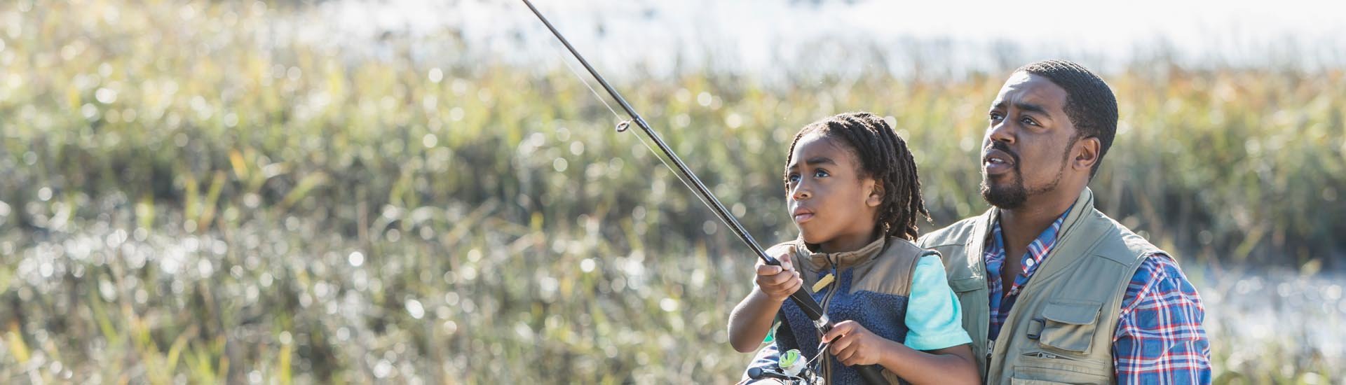 father fishing with daughter off dock